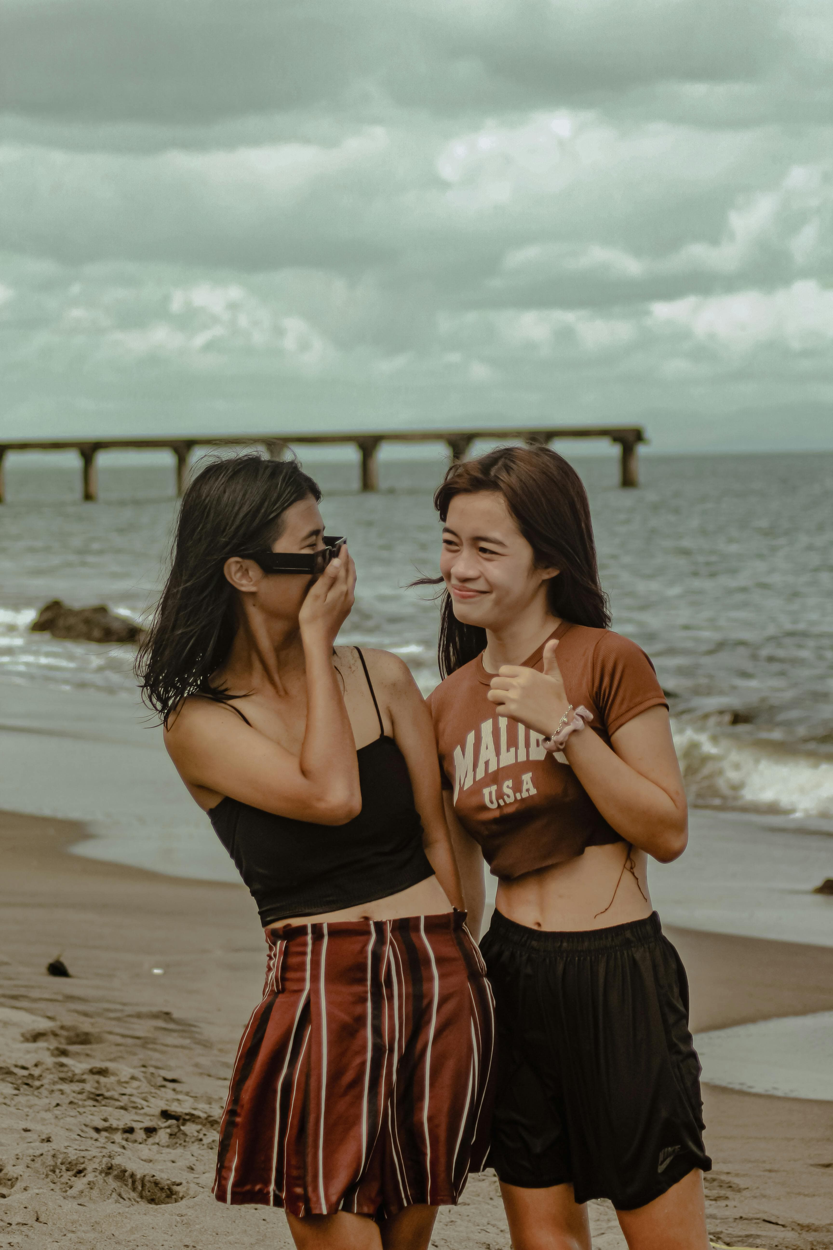 Two close friends hugging, one wearing a Memoura pendant